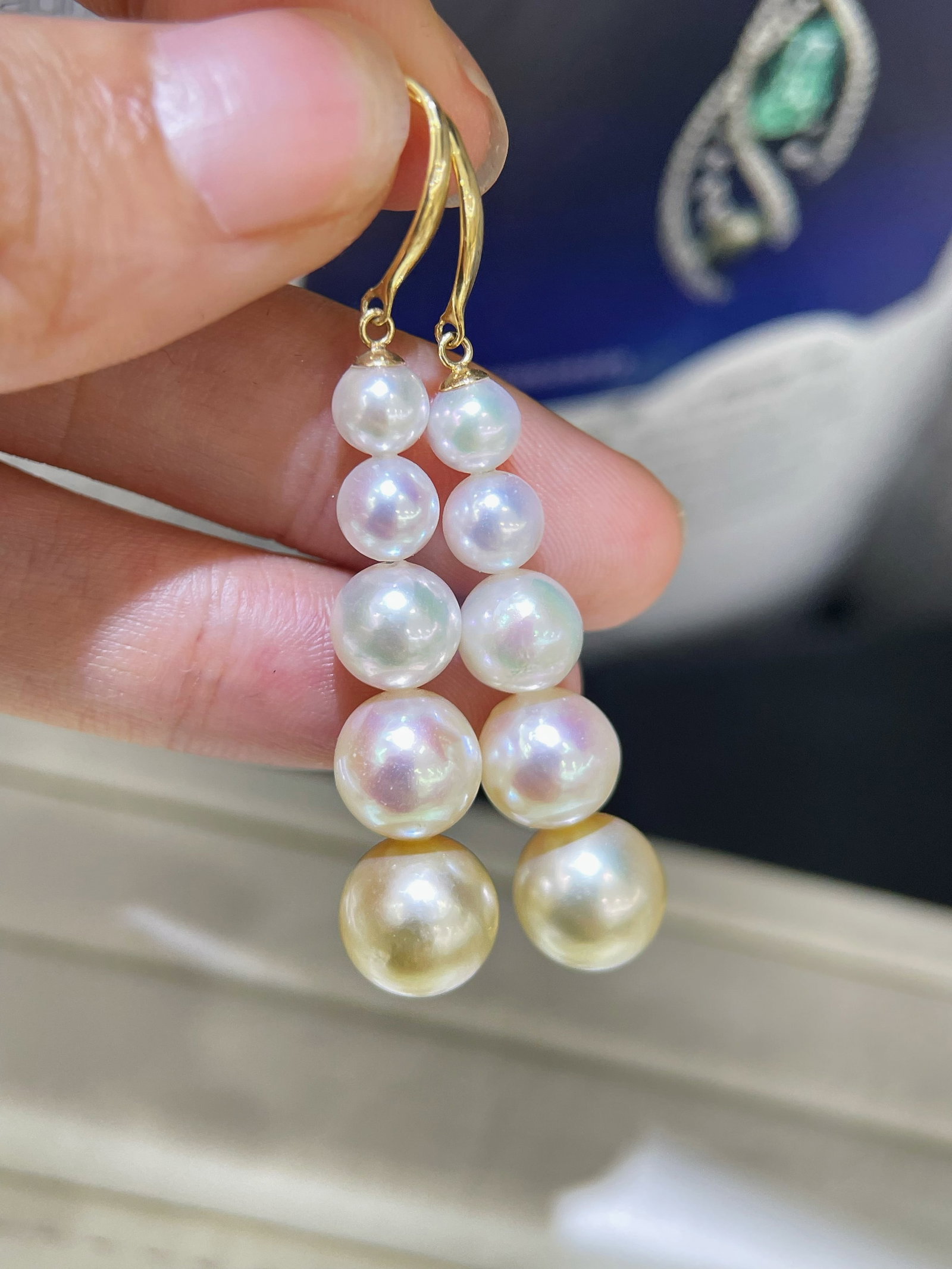 18K Gold Pearl Ear Hooks: Title: 18K Gold Pearl Ear Hooks Description: These earrings are crafted from 18K gold with a simple and elegant design. The five pearls transition from a clear cool white at the top to a champagne