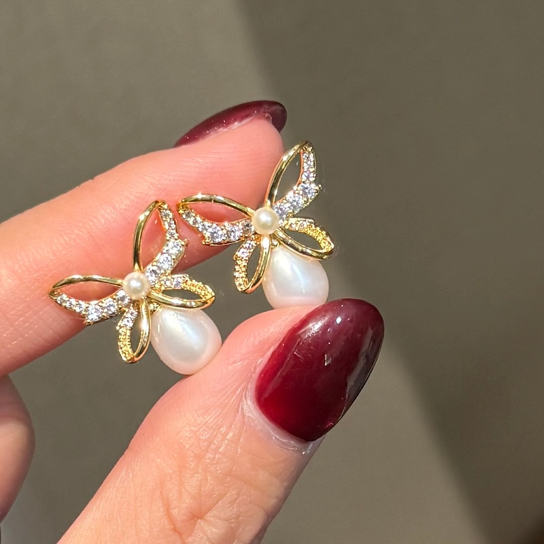 Natural High-Quality Freshwater Pearl Earrings: Title: Natural High-Quality Freshwater Pearl Earrings Description: These earrings feature an elegant bow design paired with teardrop-shaped natural freshwater pearls, showcasing a perfect blend of