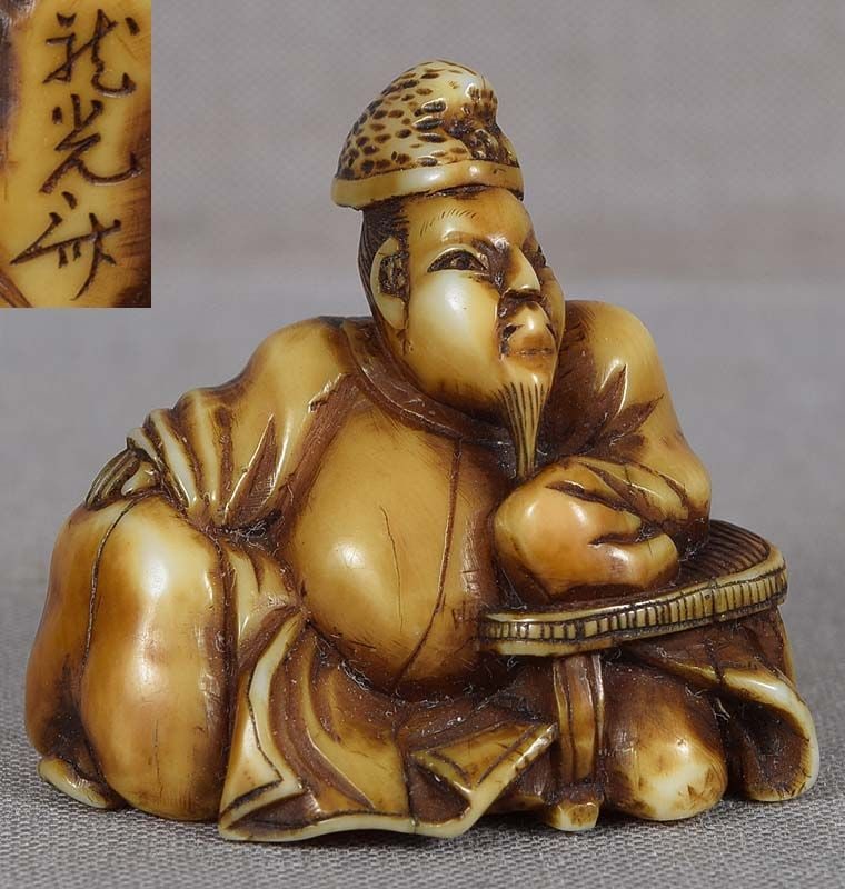 19c netsuke poet HITOMARO by RYUKOSAI ex MANG: 19th century netsuke of poet Hitomaro wearing his official coat and ritual hat, leaning on a low table thoughtfully contemplating the world as if seeking inspiration for one of his poems. Kakinomoto n