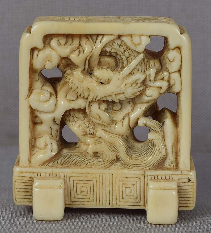 19c netsuke DRAGON SCREEN: Unusual 19th century netsuke of a floor screen with pierced decoration of a dragon in flight among clouds over cresting waves. Appears to be a reference to the Chinese legend of a artist painting a dr