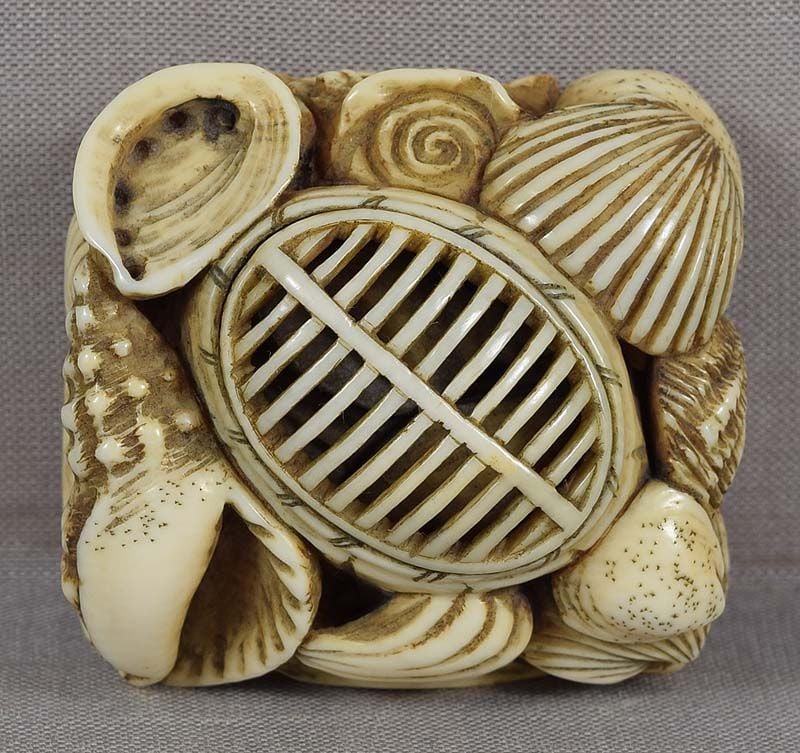 Early 19c netsuke KENDO HELMET breastplate, seashells: Early 19th century netsuke carved as a Japanese martial arts MEN (kendo helmet) resting on a DŌ (breast protector) surrounded by a pile of seashells. Unique subject, a bit of a zen puzzle