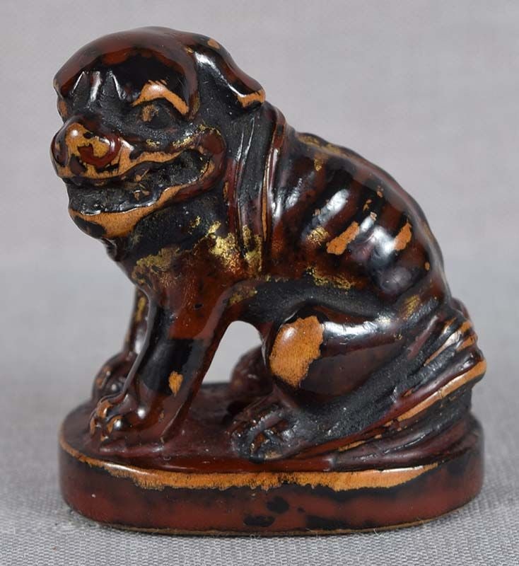 Early 19c Negoro lacquer netsuke SHISHI: Early 19th century wooden netsuke of a snarling shishi (Buddhist lion) seated on a base. Wood is lacquered in Negoro style - golden lacquer over dark red/brown over black, so as it wears first red,