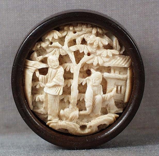 19c netsuke SCHOLARS in garden: 19th century kagamibuta (mirror lid) netsuke, the top being Chinese carving adopted as netsuke, with deeply undercarved scene of 2 scholars among trees and pavilions. Beautiful wear and patina,