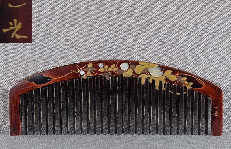 19c Japanese lacquer buffalo horn KUSHI hair comb by IKKO: Late Meiji period (1890s 1912) Japanese buffalo horn kushi (hair comb) with lacquer decoration of a vine with buds and flowers and mother-of-pearl inlays, design continuing on both sides. Signed IKKO