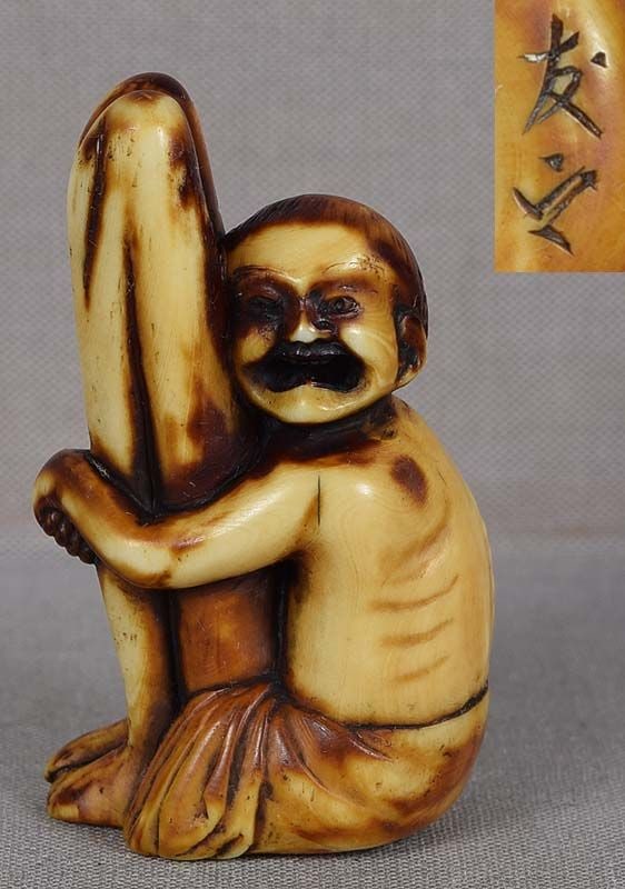 19c marine netsuke seated ASHINAGA by TOMOYUKI: 19th century marine netsuke depicting Ashinaga (long legs) wearing South Sea Islander’s sarong as he sits hugging his absurdly long legs. In Japanese legends he is often accompanied by Tenaga (l