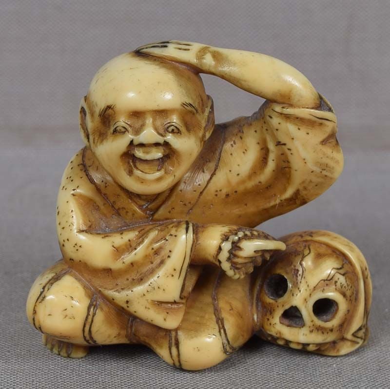 19c netsuke POET / PRIEST IKKYU with skull: 19th century netsuke of a Buddhist priest and famous 14th century poet Ikkyu seated next to a human skull and pointing at it as a reminder that all living things must ultimately die. Uncommon