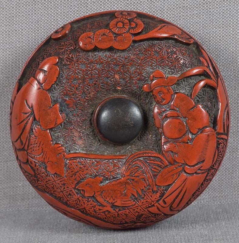 19c Japanese lacquer netsuke SCHOLARS, COCK FIGHT boy chicks: 19th century Japanese tsuishu (cinnabar lacquer) netsuke carved on the front with 3 scholars under a pine tree watching a cock fight, and the back with a boy feeding a chick and a hen by a peony bush,