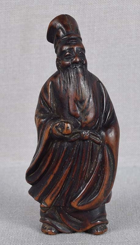 19c netsuke SENNIN TOBOSAKU with peach: 19th century boxwood netsuke of Sennin Tobosaku showing off the Peach of Immortality which he stole from a tree in the garden of Seiobo, the Chinese Queen of the Fairies, where it ripens only once it