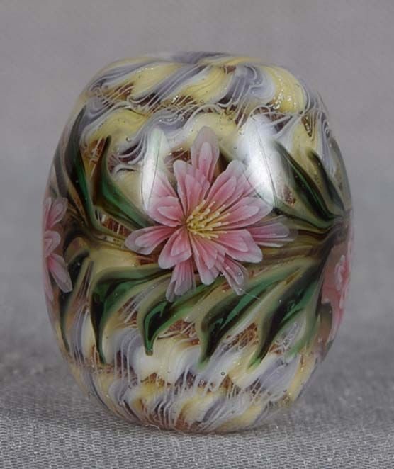 Japanese glass OJIME tombodama FLOWERS ribbon core: Japanese glass ojime in a form of tombodama bead with rich multicolored ribbon core and four pink petaled flowers with yellow stamens. Tombodama can be translated as “dragonfly ball” and