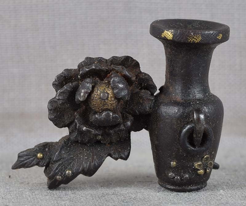 19c Japanese MAE-KANAGU pouch clasp VASE & PEONY: 19th century Japanese iron mae-kanagu (tobacco pouch clasp fitting) depicting a vase next to a peony flower with water drops on its petal. Nice touch - a ring handle on the vase moves freely. Iron is