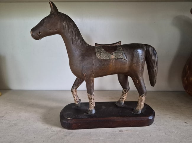 Carved and painted horse on base.: Folky horse with an English saddle. 10" long. Dry painted surface. Excellent condition. Signed P Dreterich 1931. Found in Pennsylvania. Shipping: Domestic: Shipping rates are determined by