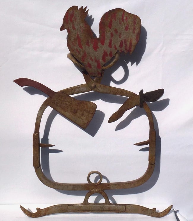 Folk art butcher's trade sign: rooster, tools and found objects: This is a folky butcher's trade sign. It is hand made from metal tools and found objects, with a sheet metal rooster on top. Ice tongs form part of the frame. It has Red and black decoration and worn