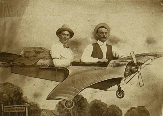 Real Photo PC Men in Fantasy Plane 1900: Real photo postcard of 2 men in a studio fantasy plane. Sign says '...Hot Springs'. Card is in good condition with a corner crease and is postally unused. Image is sharp. Please see images. Early
