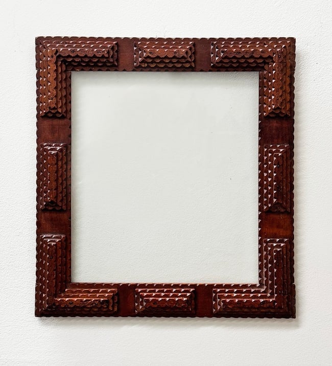 Tramp Art Frame: Tramp art frame with its original glass. Nice geometric style with crisp chip carving. Circa 1920s. 17.5" h x 15.5" w Shipping: Domestic: Flat-rate of $45.00 to anywhere within the contiguous U.S.