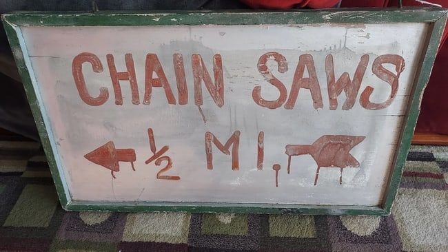 Chainsaw Repair Sign 1960 Painted 32 x 17 ": Great looking piece in very good condition. Rare piece and came from Vermont area. Reused sign. can make out sign underneath. Very common for things in New England to be reused. Measures