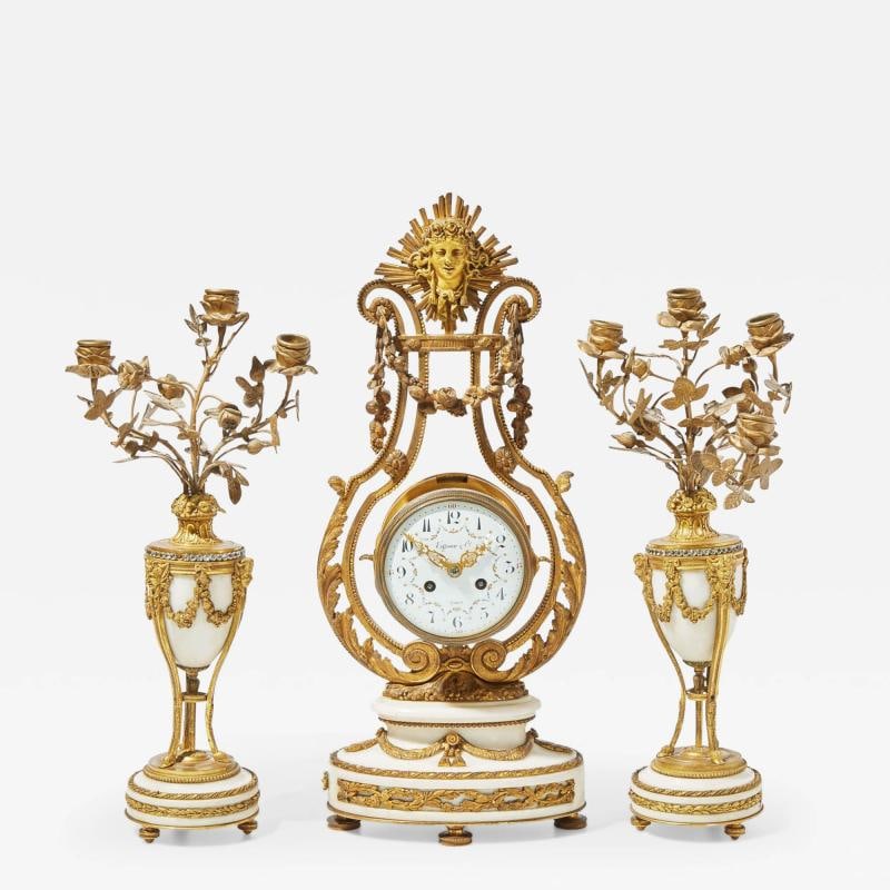 Tiffany & Co, French Louis XVI, Clock, Garniture Set, Bronze, Marble, France: Description: Tiffany French Louis XVI Clock Garniture Set, Bronze, Marble, 19th/20th Century A French Louis XVI style three-piece gilt bronze and white marble clock garniture, retailed by Tiffany & Co
