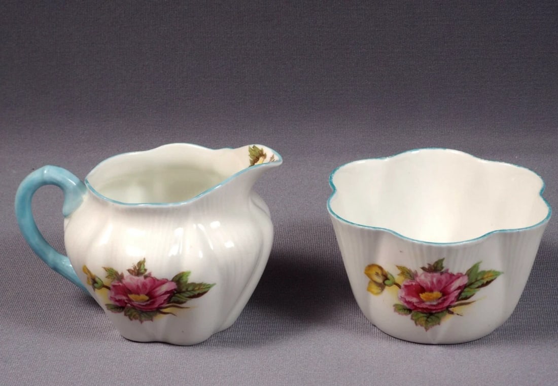 Shelley Begonia Dainty Shape Creamer Jug Milk Sugar Set Bone China: This is a beautiful and timeless Fine Bone China Creamer and Sugar Bowl, made by Shelley England in the famous Begonia pattern. The set is in the Shelley famous Dainty shape. The set is properly marke