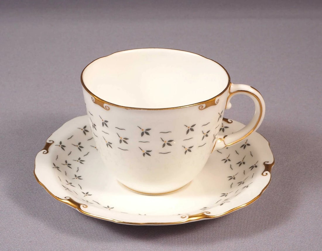ROYAL CROWN DERBY SANDBY A1114 Tea Coffee Cup Saucer Gold Gray England: This is a beautiful and timeless Tea/Coffee Cup with Saucer made by Royal Crown Derby. The set is in Sandby pattern. It is decorated in the gray leaves and gold dots with gold rim. The set is marked w