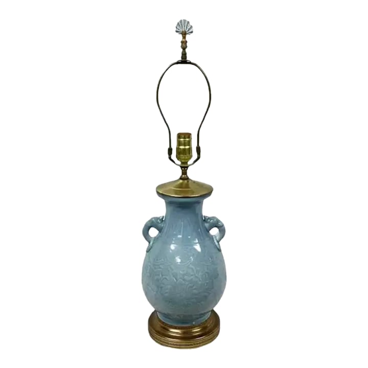Chinese Gilt Brass Mounted Celadon Porcelain Lamp: Mid 20th Century Chinese Gilt Brass Mounted Celadon porcelain lamp with molded elephant ring handles and matching finial. Harp and finial included. Molded blue floral motif throughout lamp. Mounted
