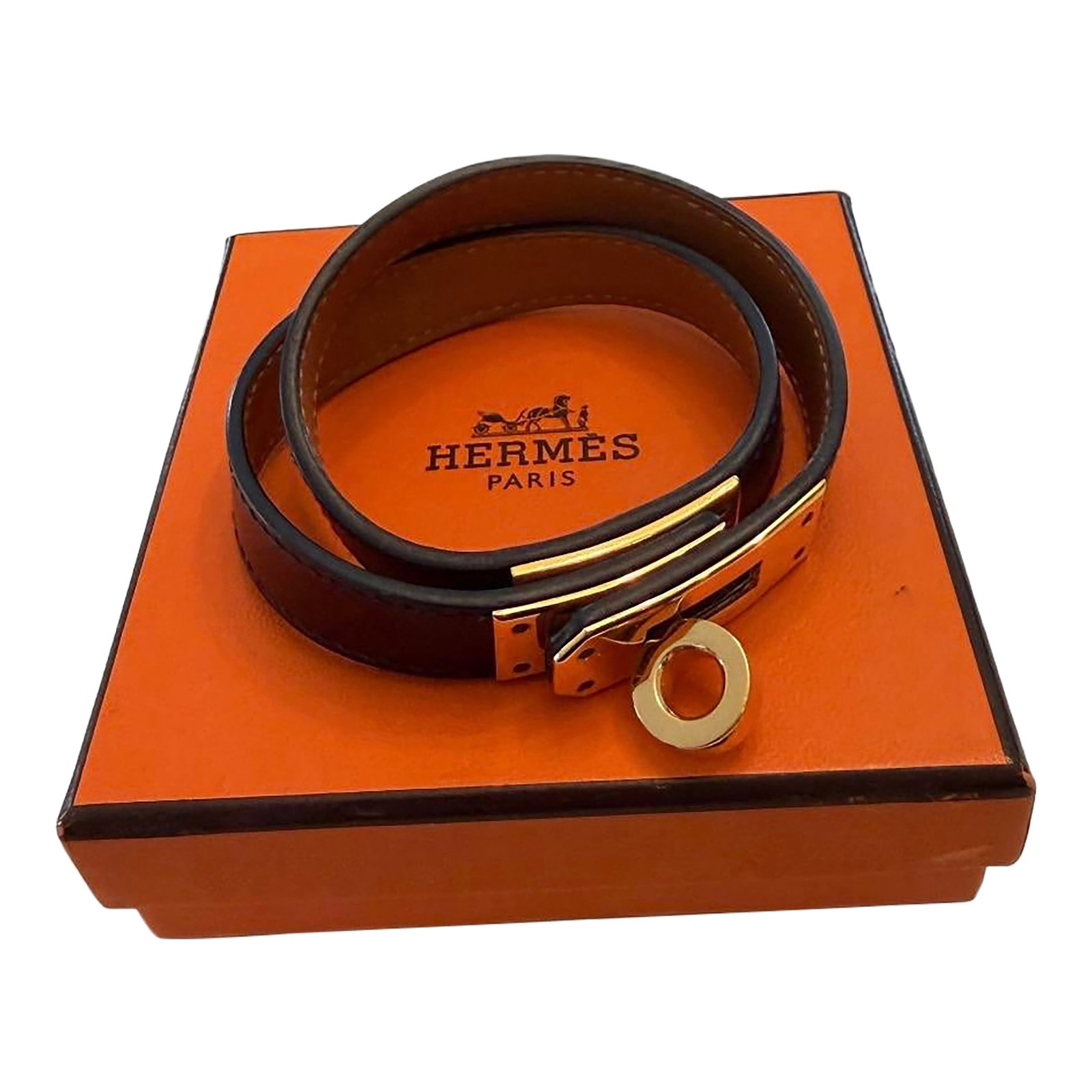 Hermès Kelly Double Tour Bracelet in Black Leather With Gold-Plated Hardware: Hermès Kelly Double Tour Bracelet in black leather with brown felt bag and iconic orange logo box for storage. Double leather band fits wrist size S/M. Interior is stamped: Hermès Paris X