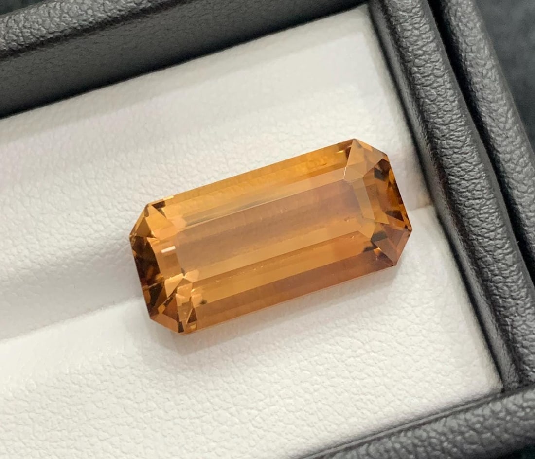 Rich Brown Topaz Gemstone: Long Emerald Cut, November Birthstone (17.50 Carat): Gemology: * Weight : 17.50 carat * Dimension : 20.5*10.1*8.5 mm * Color: Brown * Clarity : Loupe Clean * Shape : Long Emerald Cut * Hardness : 8 * Origin : Skardu, Pakistan * Luster: Vitreous *