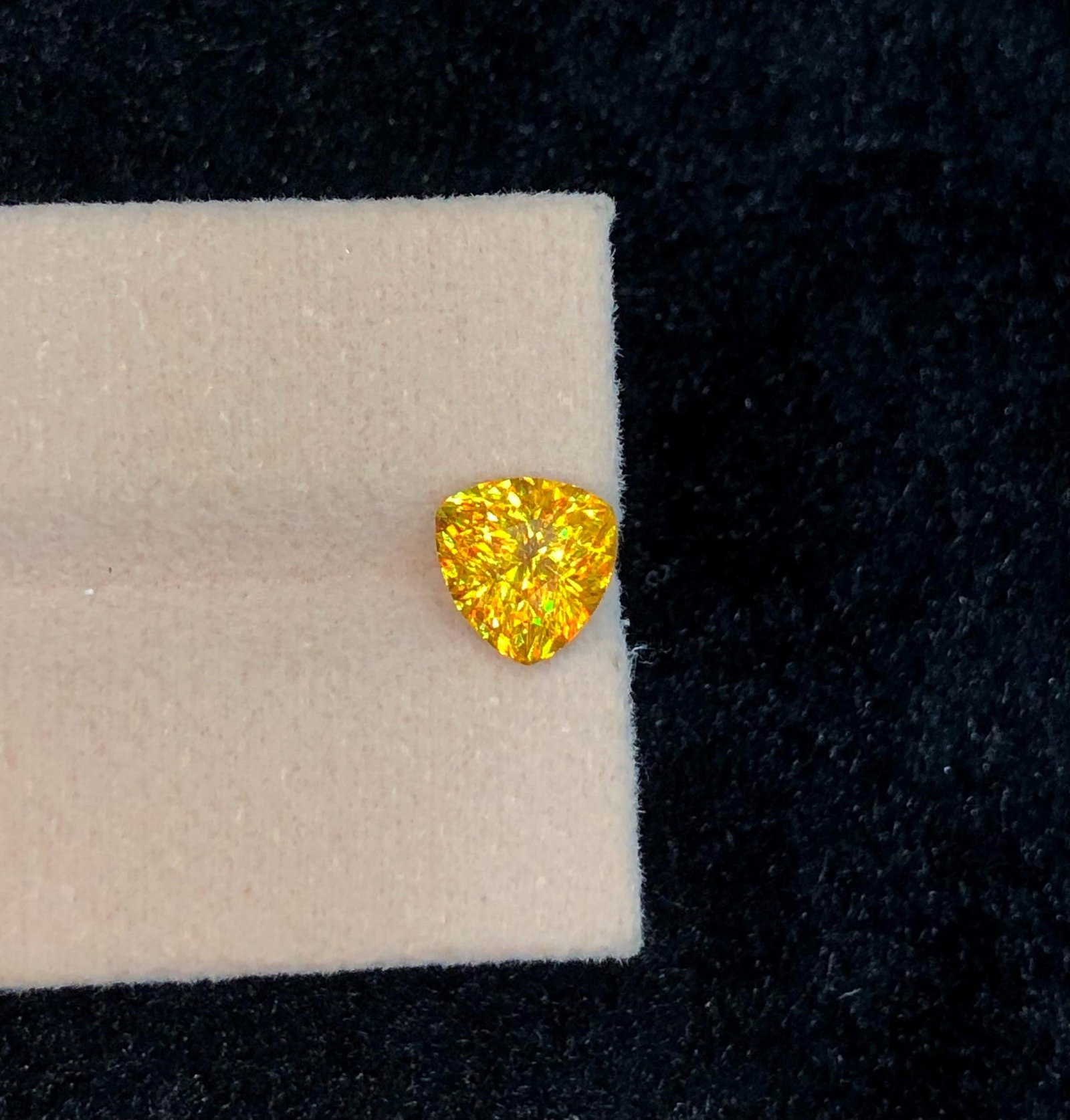 Trillion Cut Sphene Titanite Gemstone: Yellow Orange Sparkle, 2.245 Ct: This stunning full fire sphene titanite loose gemstone features a captivating Trillion cut that enhances its brilliance and beauty. With its vibrant play of colors and exceptional clarity, this gemsto