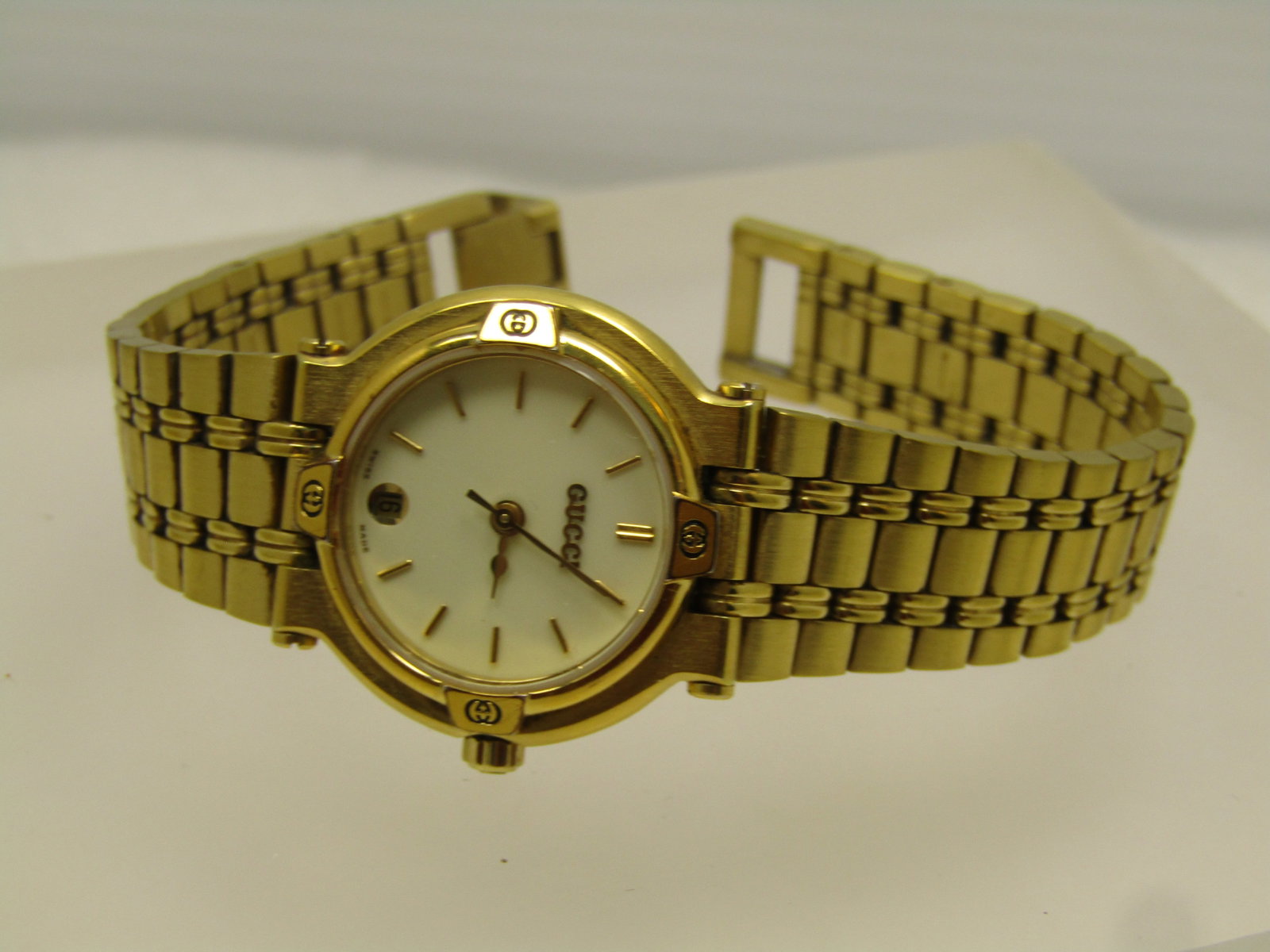 Ladies' Gucci Gold Tone Watch with Date and Second Hand, 1980's-1990's, Runs: Ladies' Gucci Gold Tone Watch with Date and Second Hand, 1980's-1990's, Runs. 25mm case, analog, Swiss Made with brushed bracelet style watch band with flip clasp. Dial is white with the Gucci marks