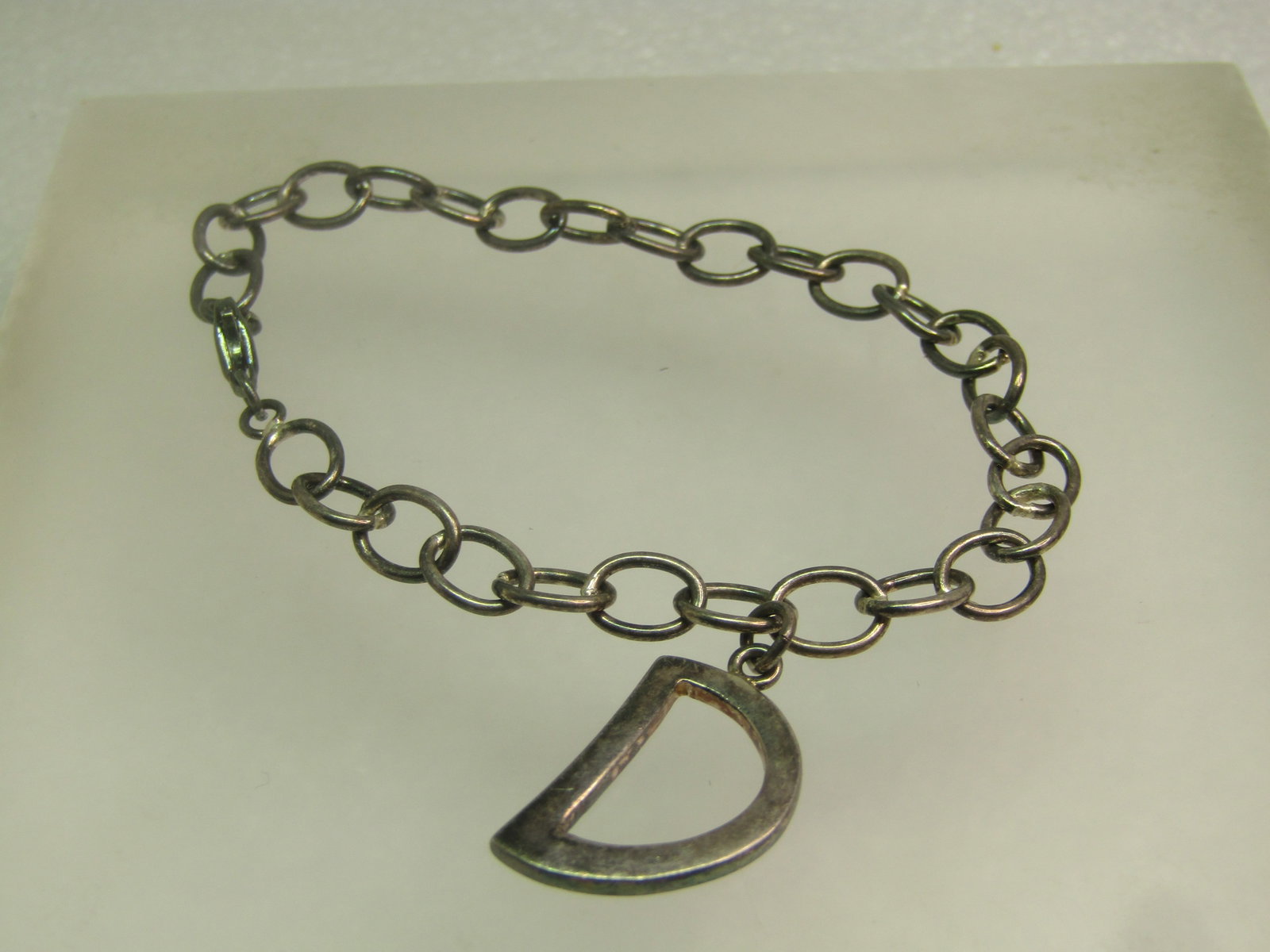 Vintage Sterling Bracelet with D Charm, 7", Signed M, 1980's-1990's: Vintage Sterling Bracelet with D Charm, 7", Signed M, 1980's-1990's. This is made with oval links that are appx. 5.5mm wide. There is an appx. 7/8" D charm that hangs from the bracelet and is just und