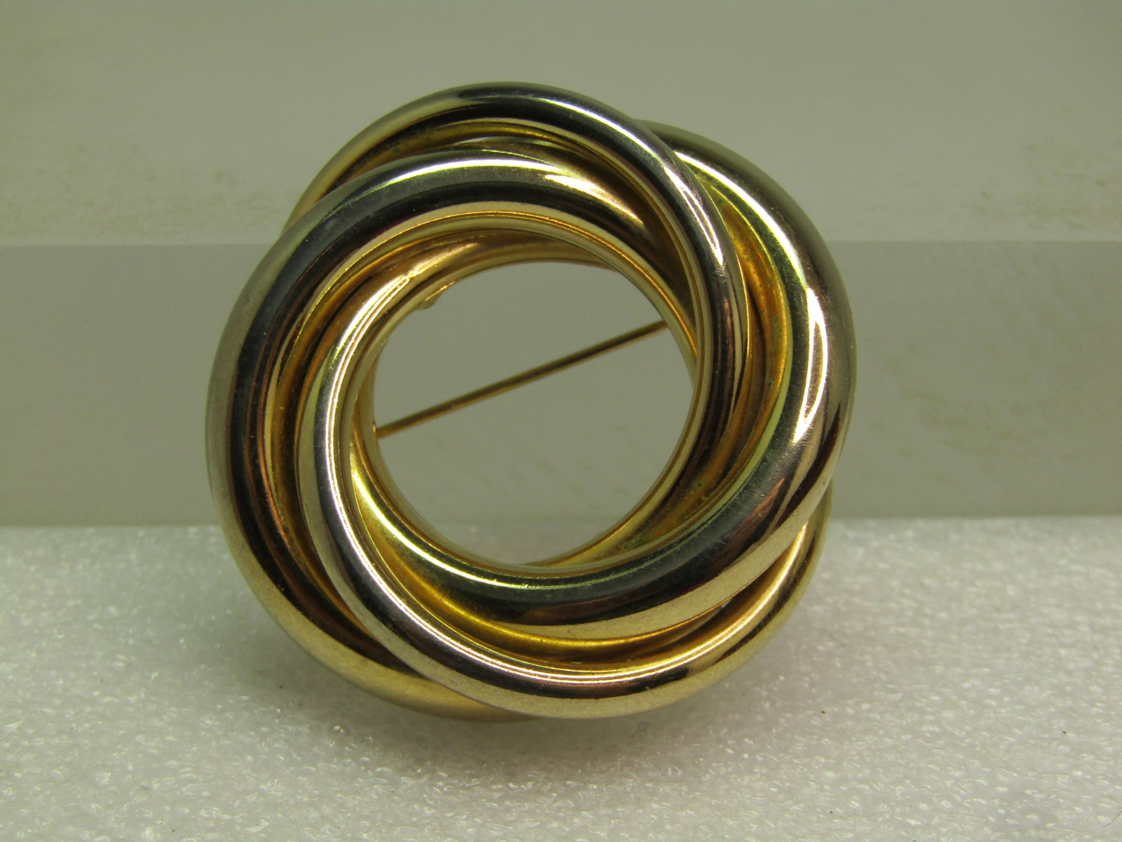 Vintage Trinity Circle Brooch, Gold Tone, 1960's-1970's: Vintage Trinity Circle Brooch, Gold Tone, 1960's-1970's. This is appx. 1.75" across with three thicknesses of interwoven circles that are appx. 3.5mm; 4mm; and 5.5mm. Locking clasp. This is nto