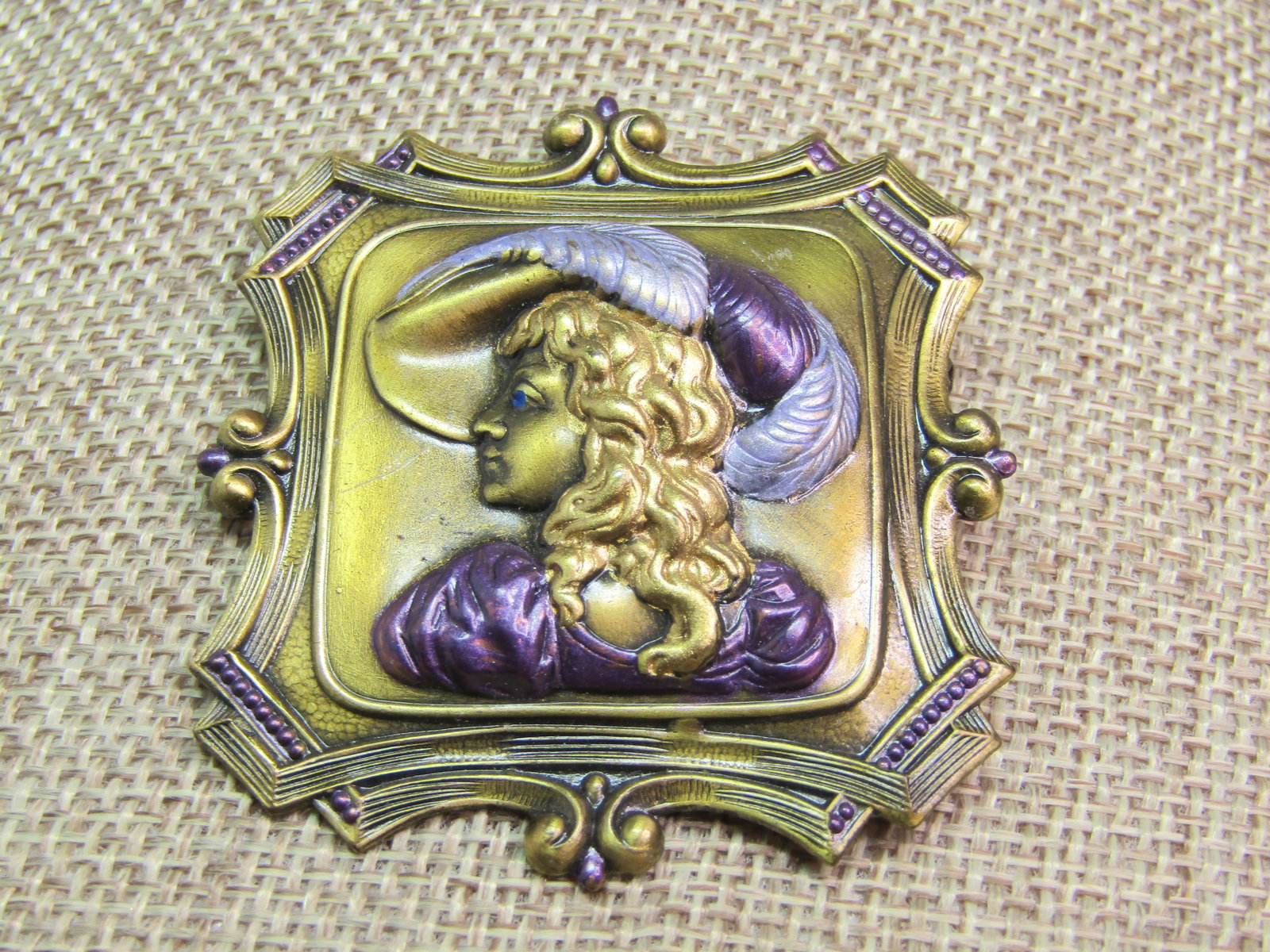 Vintage Faux Art Nouveau Woman in Hat Brooch, Enameled, 1980's: Vintage Faux Art Nouveau Woman in Hat Brooch, Enameled, 1980's. Enameled with lavender and purple on the feathers in the hat and her dress. Intricate frame. It is appx. 2" tall and wide. Brassy gold