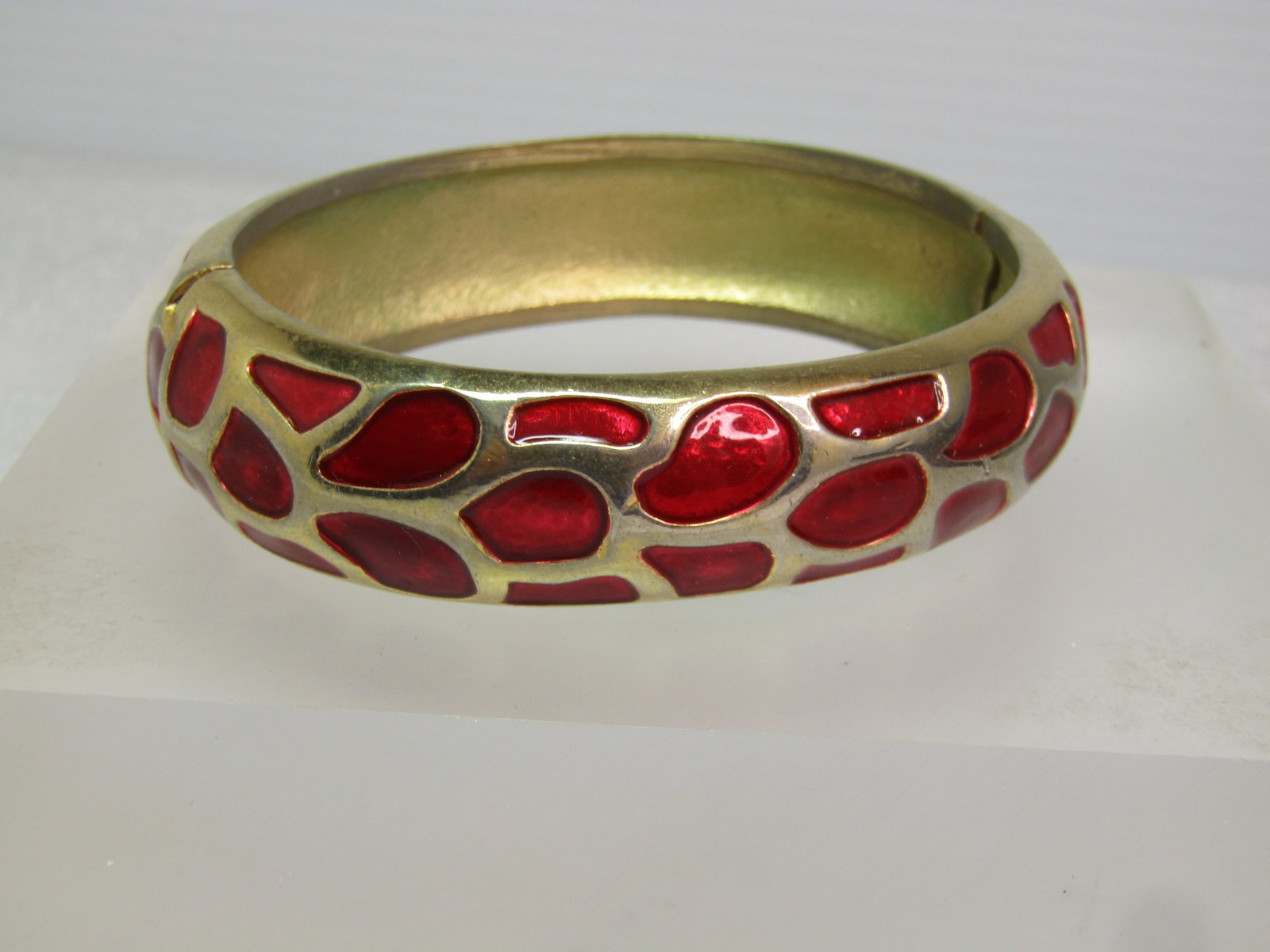 Vintage Red Enameled Animal Print Bracelet, Hinged/Locking, 6.5", 1970's-1980's: Vintage Red Enameled Animal Print Bracelet, Hinged/Locking, 6.5", 1970's-1980's. Gold toned and recessed animal print design filled with a shimmery red enameling. Side lock on the bracelet which is