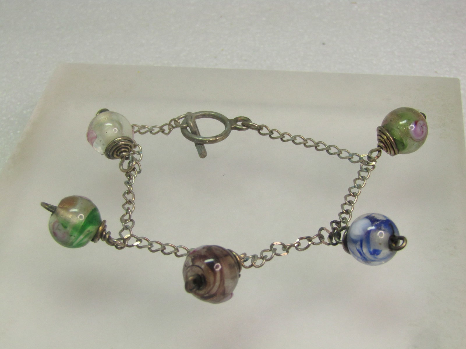 Vintage Art Glass Beaded Bracelet, Sterling Chain, 7.25", 1970's-1980's: Vintage Art Glass Beaded Bracelet, Sterling Chain, 7.25", 1970's-1980's. toggle clasp - the clasp does not test as sterling but the chain does. There are five 10.5mm round glass beads with rose design