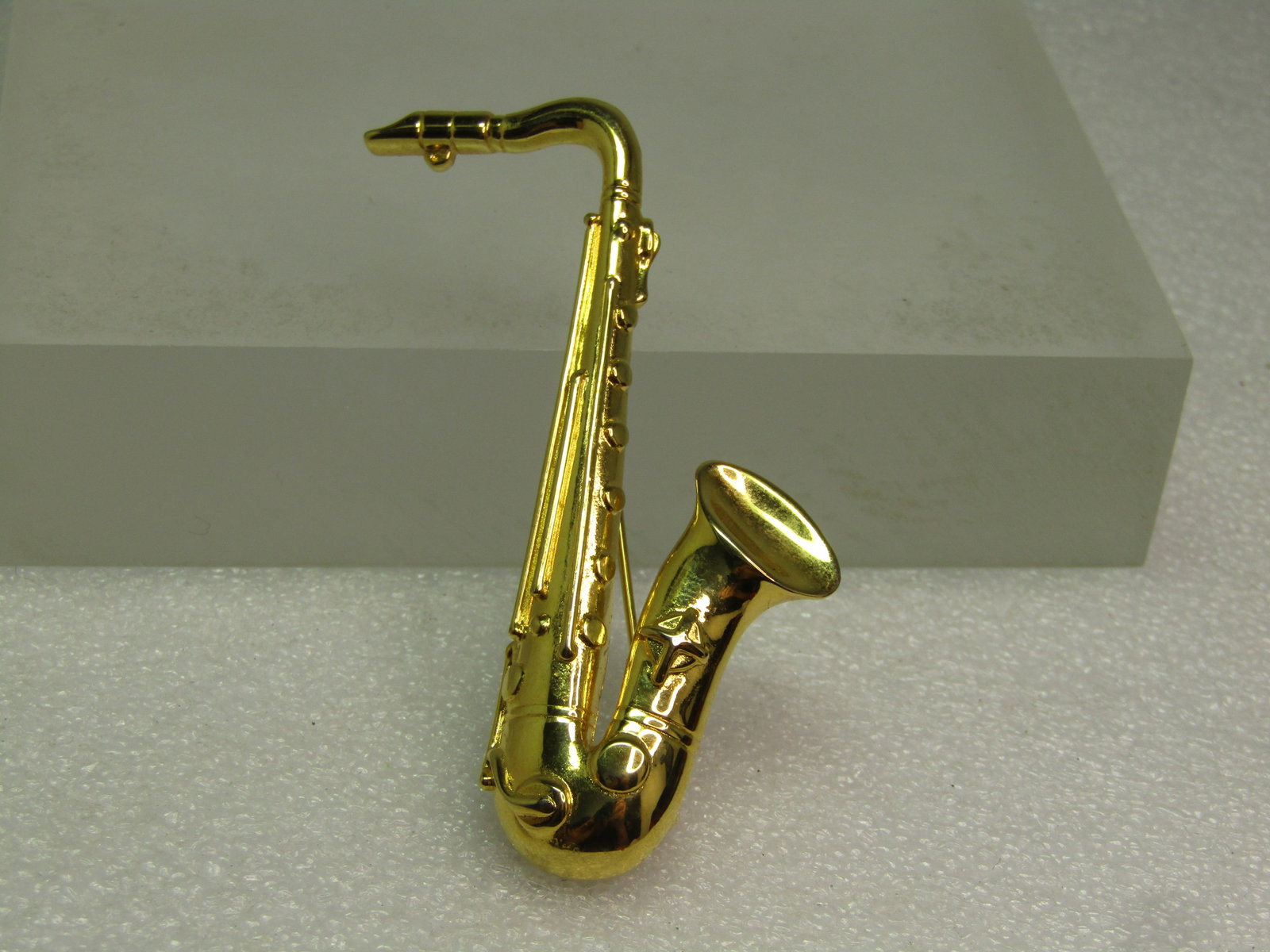 Vintage Saxophone Brooch, 1970's-1980's: Vintage Saxophone Brooch, 1970's-1980's. Gold tone and appx. 2.75" tall and 3/4" wide. Very good condition. It is not marked or signed. (W4525.4 SS15993 J AZ LD 6/4/25). Reserve: $15.00 Shipping: