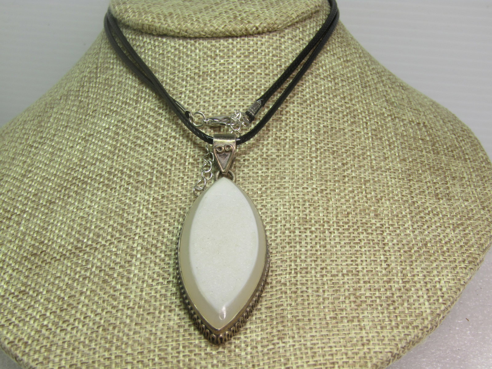 Vintage Quartz Southwestern Necklace, 24" Black Cord, 1970's-1980's: Vintage Quartz Southwestern /Bali Necklace, 24" Black Cord, 1970's-1980's. This is a cat-eye shaped stone that is appx. 53mm by 24mm with a druzy glittery top and milky white stone. It is beveled on t