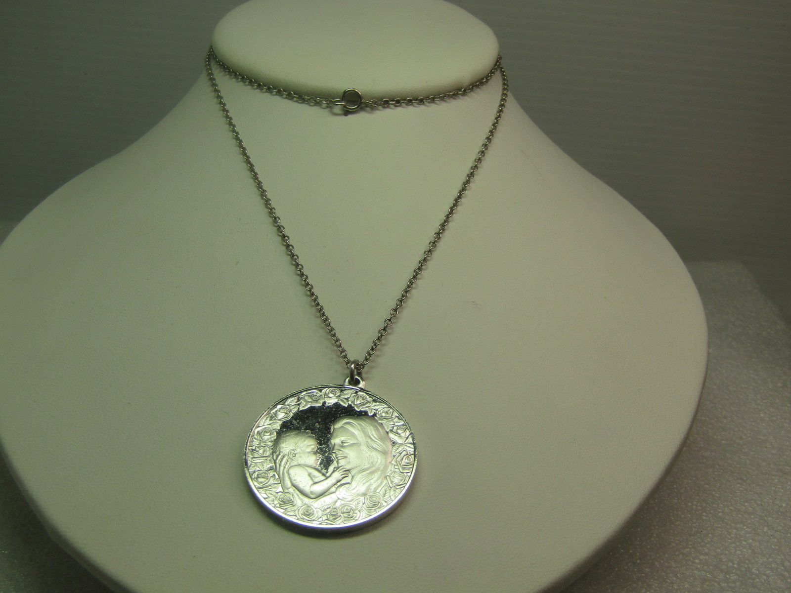 Vintage Sterling Mother's Day Necklace, 1975, Signed, 24", 17.30 grams: Vintage Sterling Mother's Day Necklace, 1975, Signed, 24", 17.30 grams. The pendant has a satin and shiny finish with raised roses and a mother holding a child - on the back are roses framing the