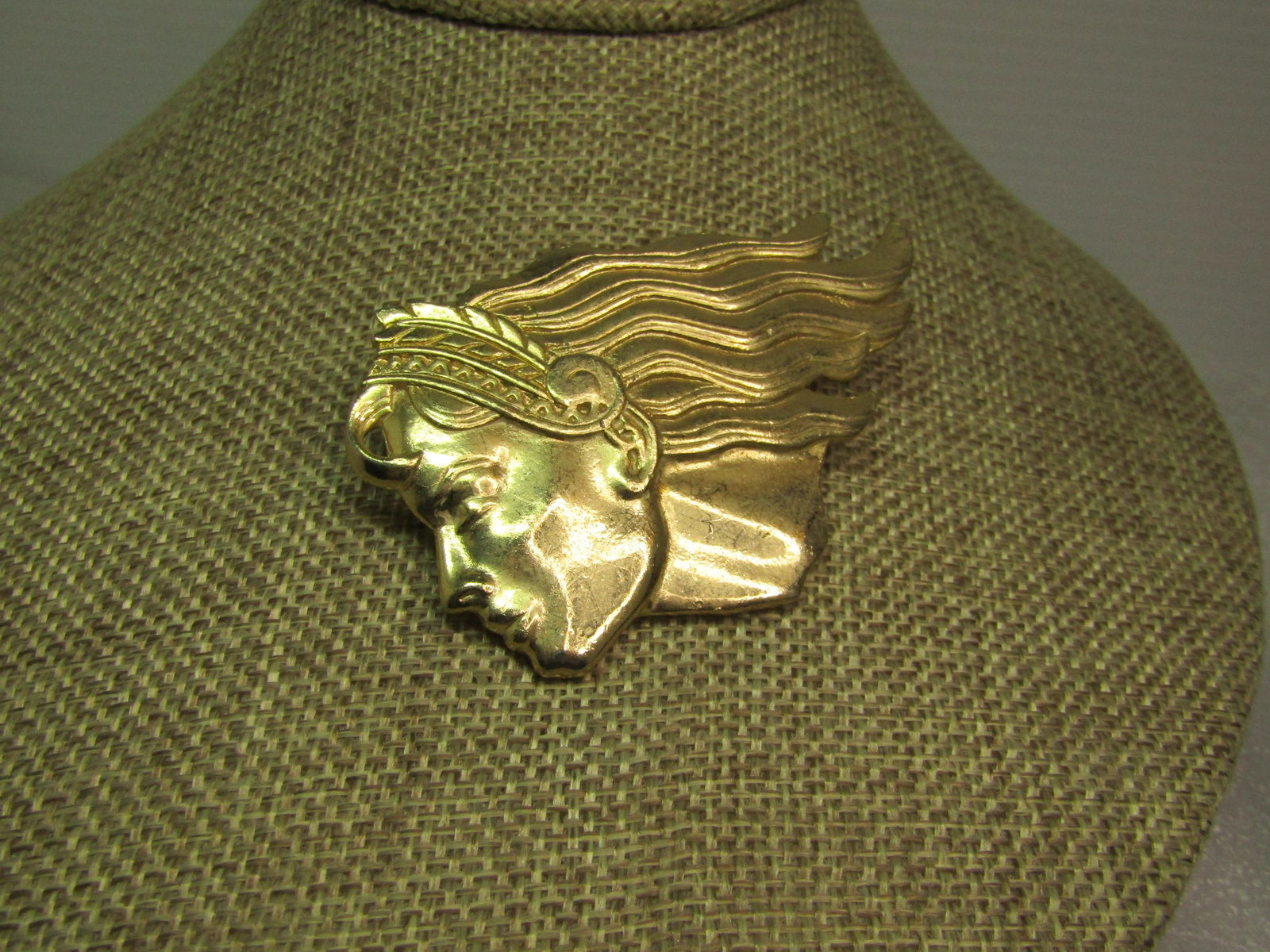 Vintage Woman with Flowing Hair Brooch, 1980's, Gold Tone: Vintage Woman with Flowing Hair Brooch, 1980's, Gold Tone. She is also wearing a headdress over the top of her head. This is appx. 2" tall and 2.75" wide. Locking clasp. It is not signed or marked.