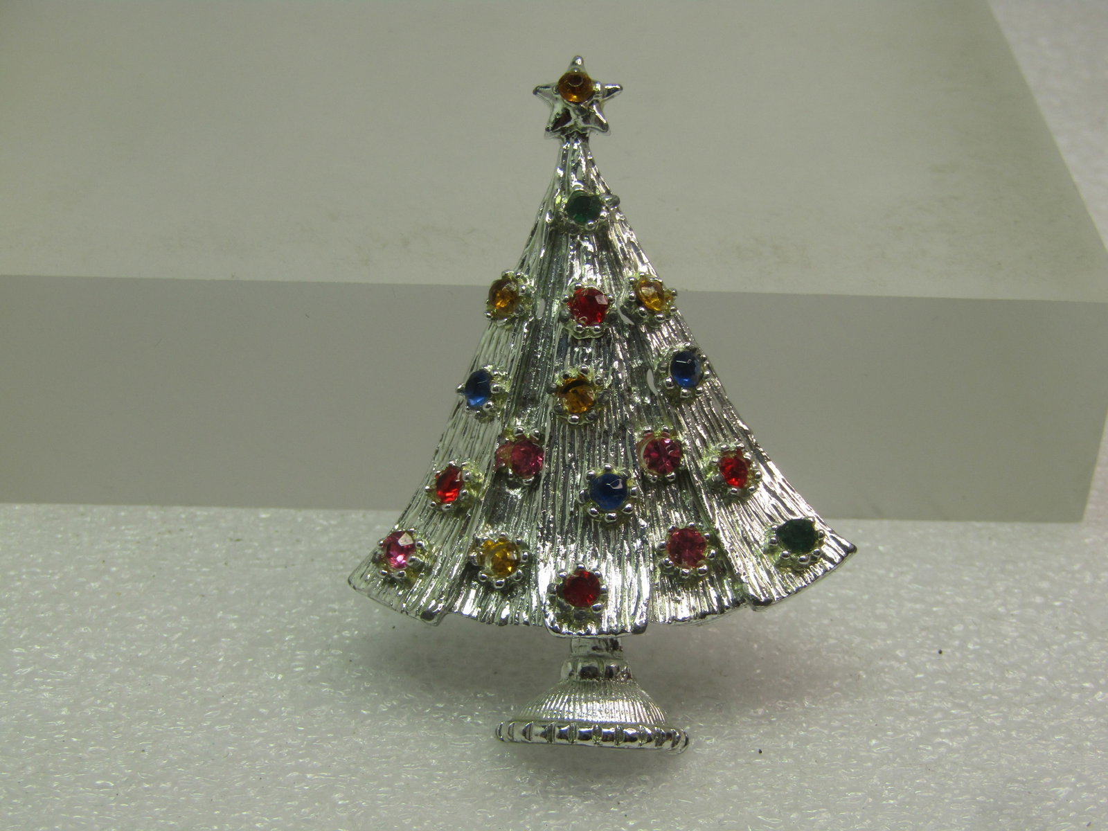 Vintage Rhinestone Christmas Tree Brooch, Silver Tone, 1960's-1970's: Vintage Rhinestone Christmas Tree Brooch, Silver Tone, 1960's-1970's. This has raised and lower vertical sections in the design and gives the brooch some depth with a star and yellow rhinestone in the