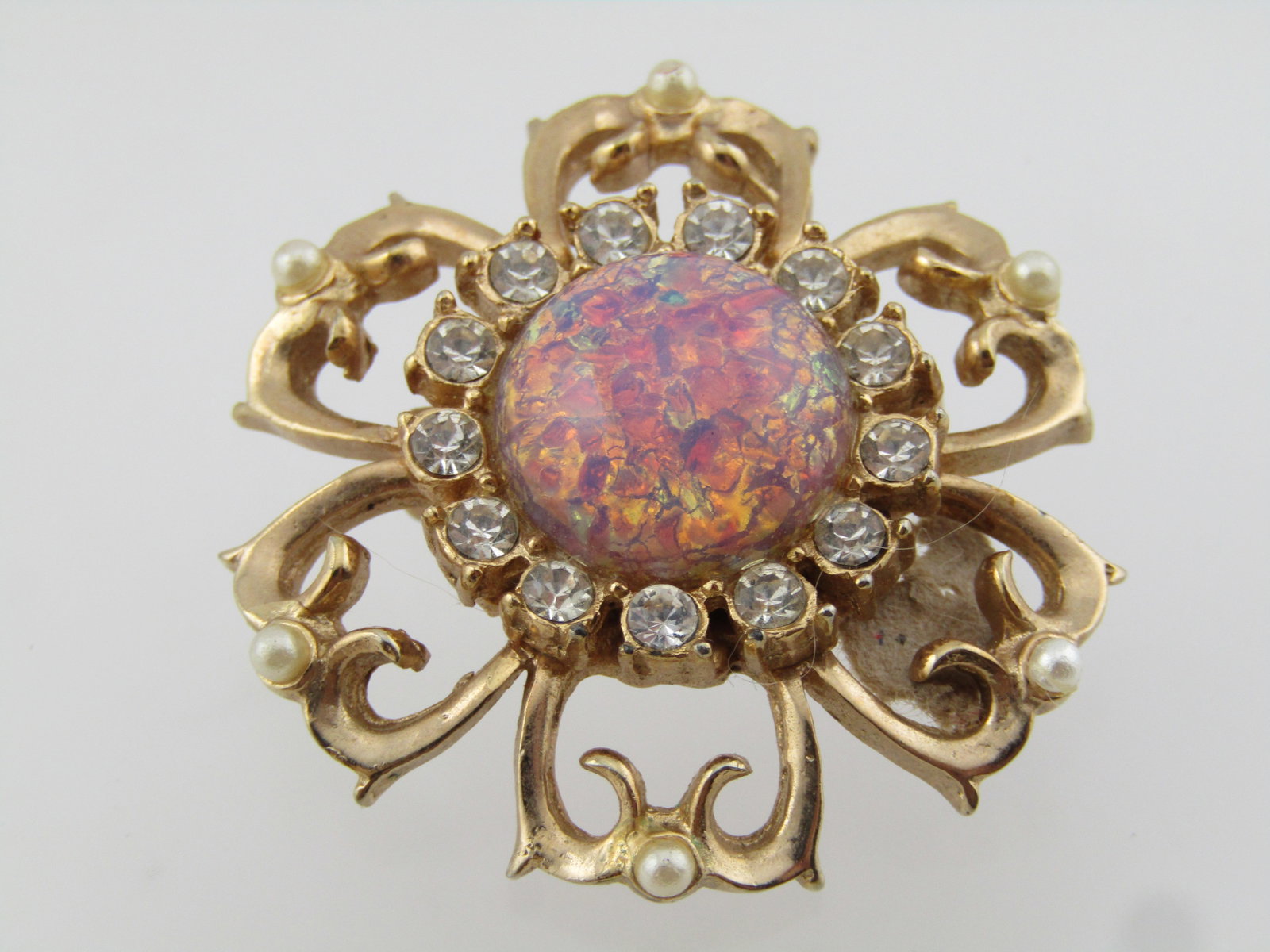 Vintage Faux Opal Rhinestone Blossom Brooch, Seed Pearls, 1950's-1960's: Vintage Faux Opal Rhinestone Blossom Brooch, Seed Pearls, 1950's-1960's. This is gold tone with six open work petals that each have a small seed pear at the center tip. The faux opal is a round dome w