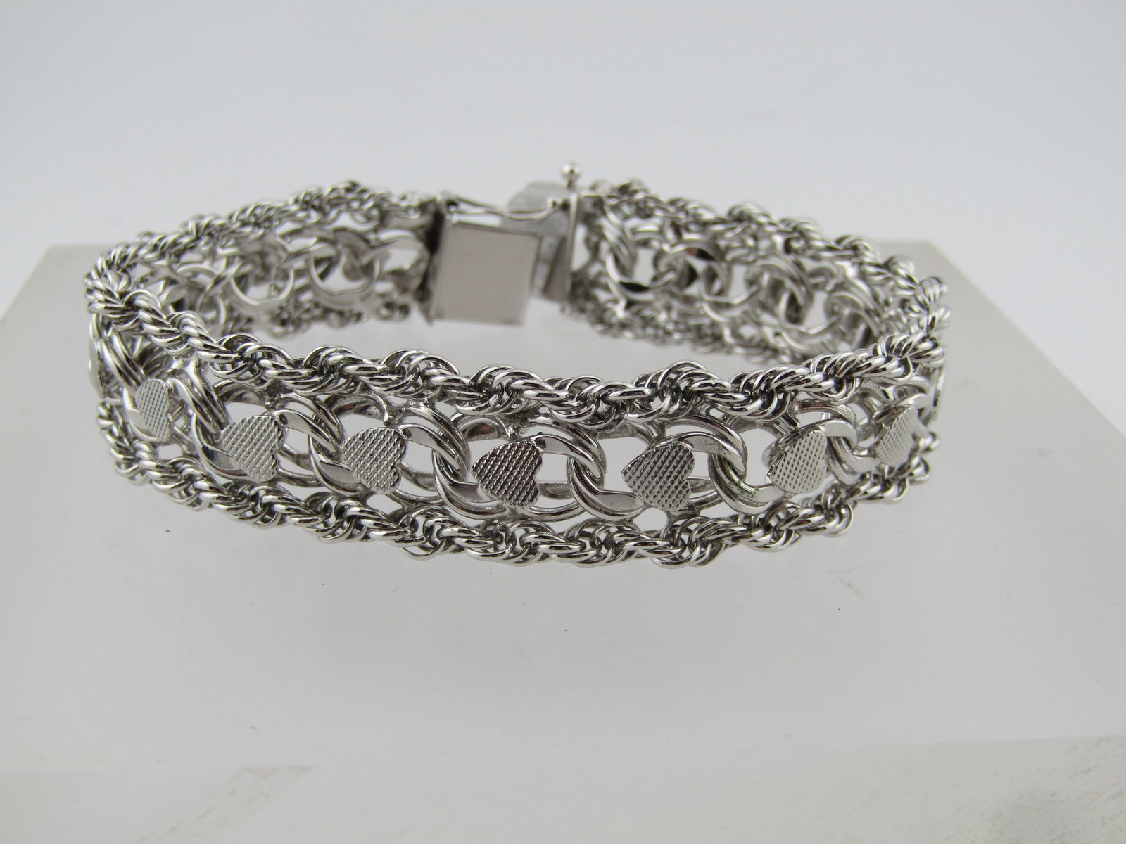 Silver Heart Wide Bracelet, 7", 3/8" Wide, Marked Sterling, 1980's-1990's: Silver Heart Wide Bracelet, 7", 3/8" Wide, Marked Sterling, 1980's-1990's. This has a twisted rope strand on each side with links between and textured heart accents down the entire center of the brace