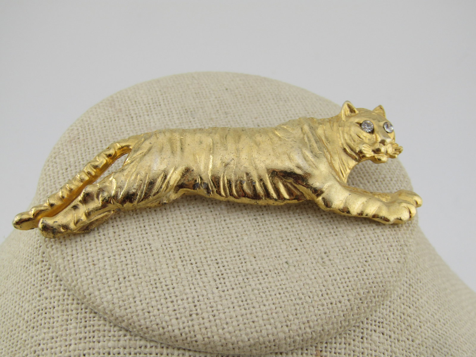Vintage Tiger Brooch, Rhinestone Eyes, 3", 1970's-1980's,: Vintage Tiger Brooch, Rhinestone Eyes, 3", 1970's-1980's. This is three inches wide and slightly over 1" tall at the widest point. It has clear rhinestone eyes. It has striped indents. It is not signe