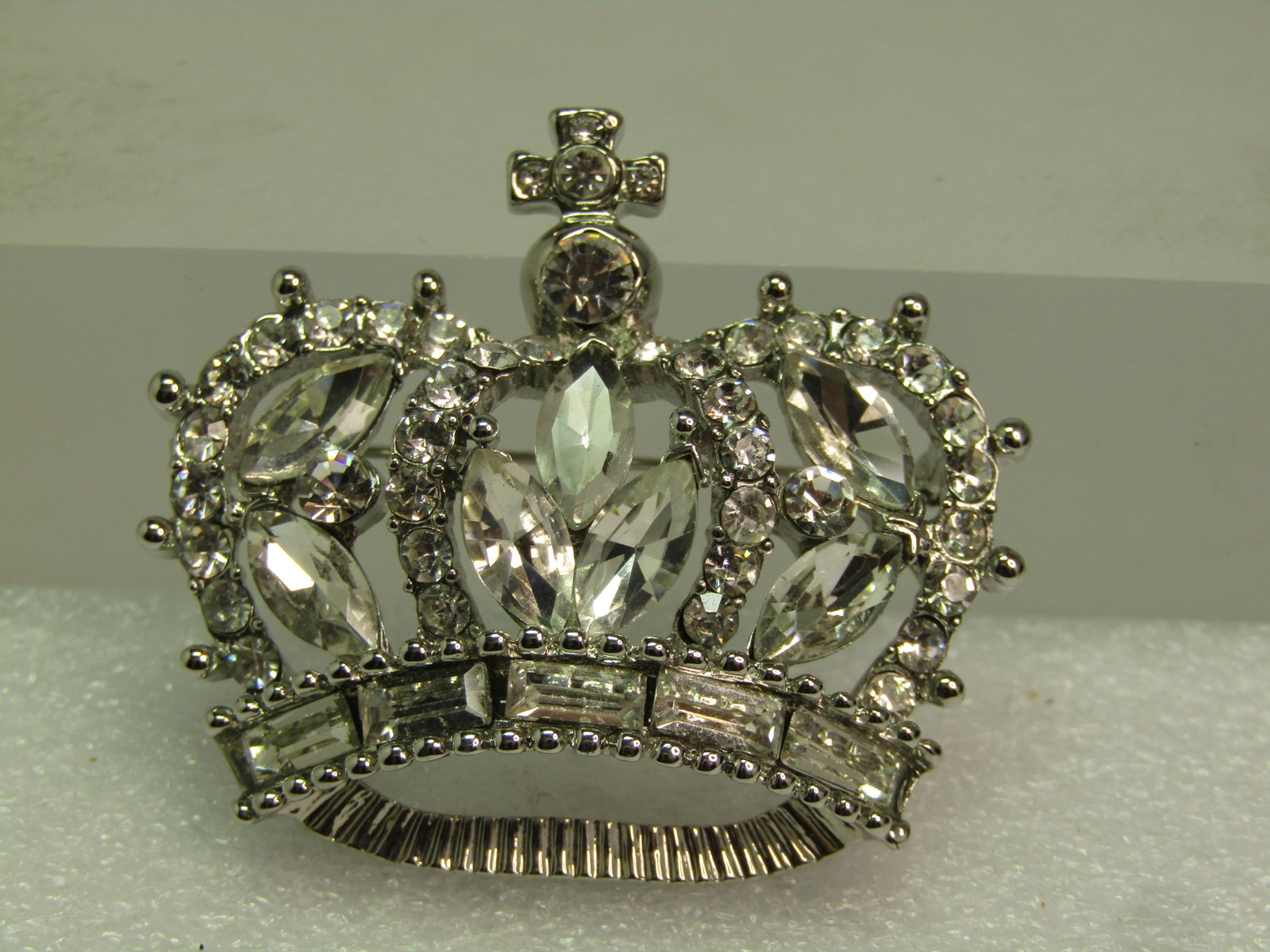 Vintage Clear Rhinestone Crown Brooch, Cross on Top, 1970's-1980's: Vintage Clear Rhinestone Crown Brooch, 1970's-1980's. This is silver tone and appx. 1.75" wide and 1.5" tall with a cross on top. The rhienstones are glass or crystal. This has marquise stones and bag
