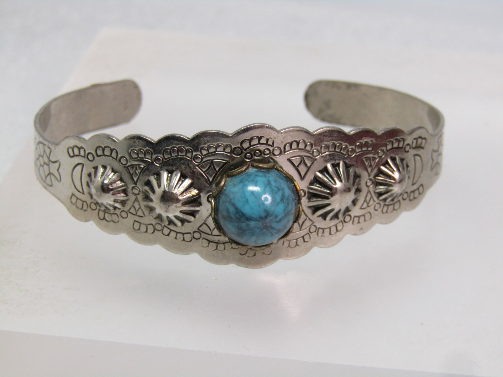 Vintage Faux Turquoise Southwestern Cuff Bracelet, 6.5", 1960's-1970's: Vintage Faux Turquoise Southwestern Cuff Bracelet, Unisex, 6.5", 1960's-1970's. This is a silver tone costume southwestern bracelet with raised concho designs made intot he cuff with pressed designs o