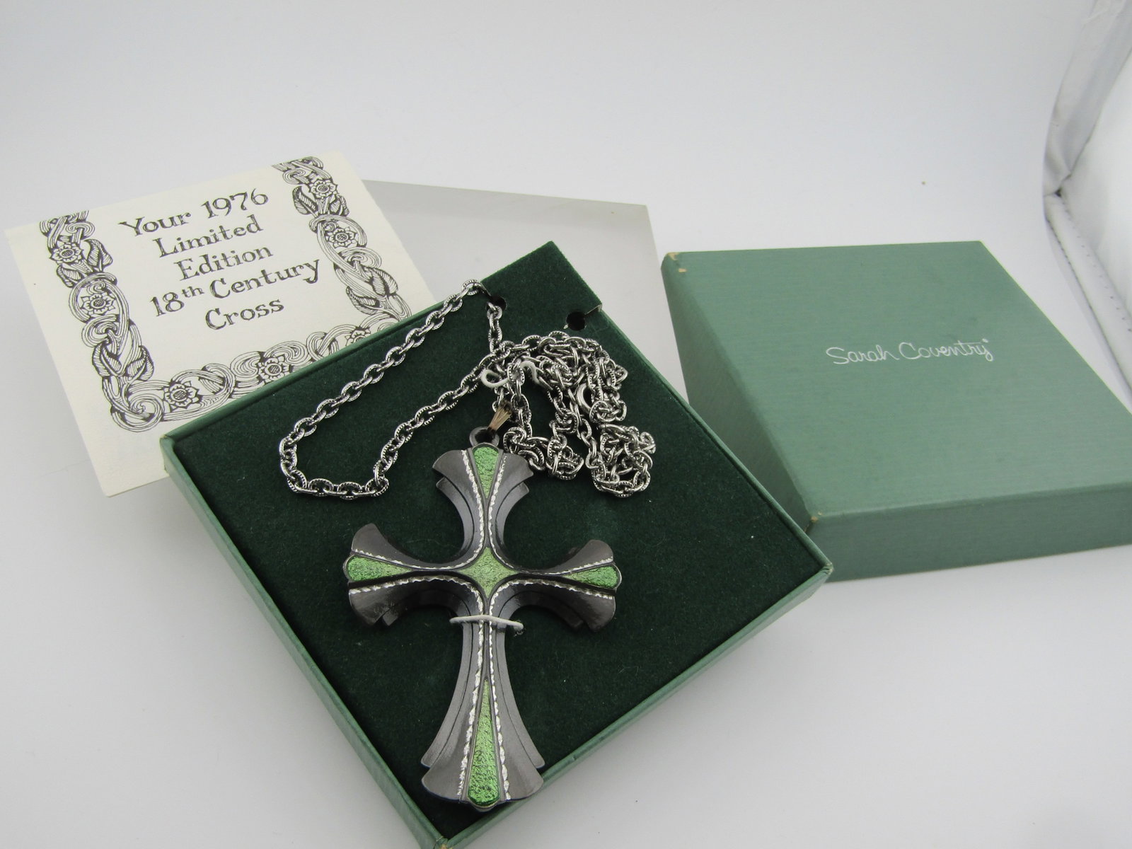Vintage Sarah Coventry 18th Century Cross Necklace, 1976: Vintage Sarah Coventry 18th Century Cross Necklace, 24". 1976. This is in the original box with paperwork. The cross is silver tone with a heavy chain and green enameled accents. Very good codnition.
