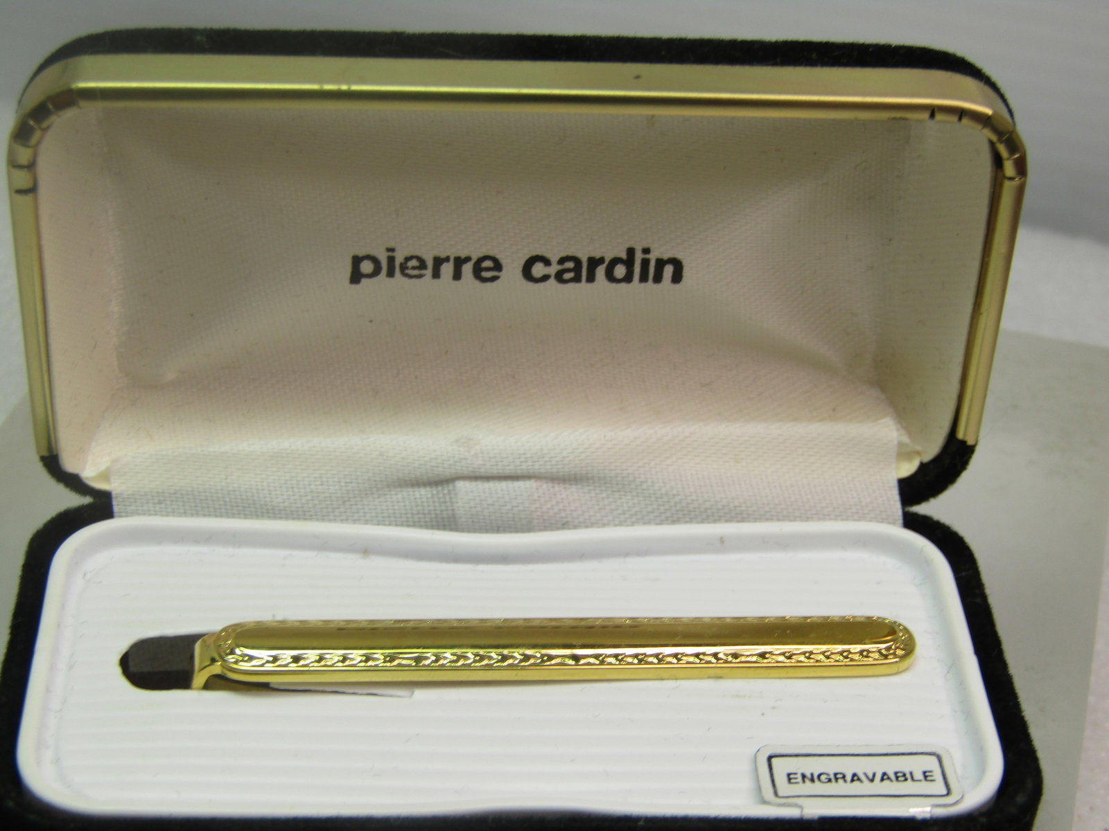 Vintage Pierre Cardin Tie Bar, Engraveable, Original Box, 1980's: Vintage Pierre Cardin Tie Bar, Engraveable, Original Box, 1980's. It is gold tone and appx. 2-1/8" wide and 1/3" tall. Very clean and unworn - excellent condition. Comes in orange black velvet box.