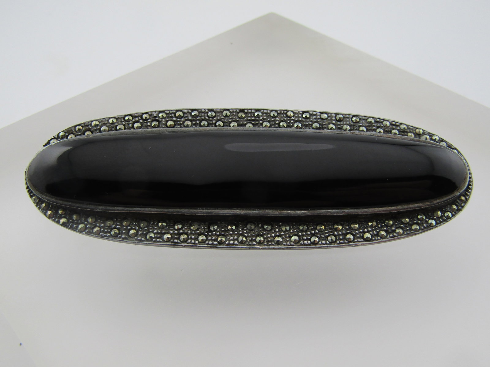 Vintage Sterling Onyx Marcasite Oval Brooch, 3", 1980's: Vintage Sterling Onyx Marcasite Oval Brooch, 3" by 1-1.8". Locking clasp. 1980's. It is marked .925 and tests as sterling with a weight of appx. 28.91 grams. This is a long brooch with a raised