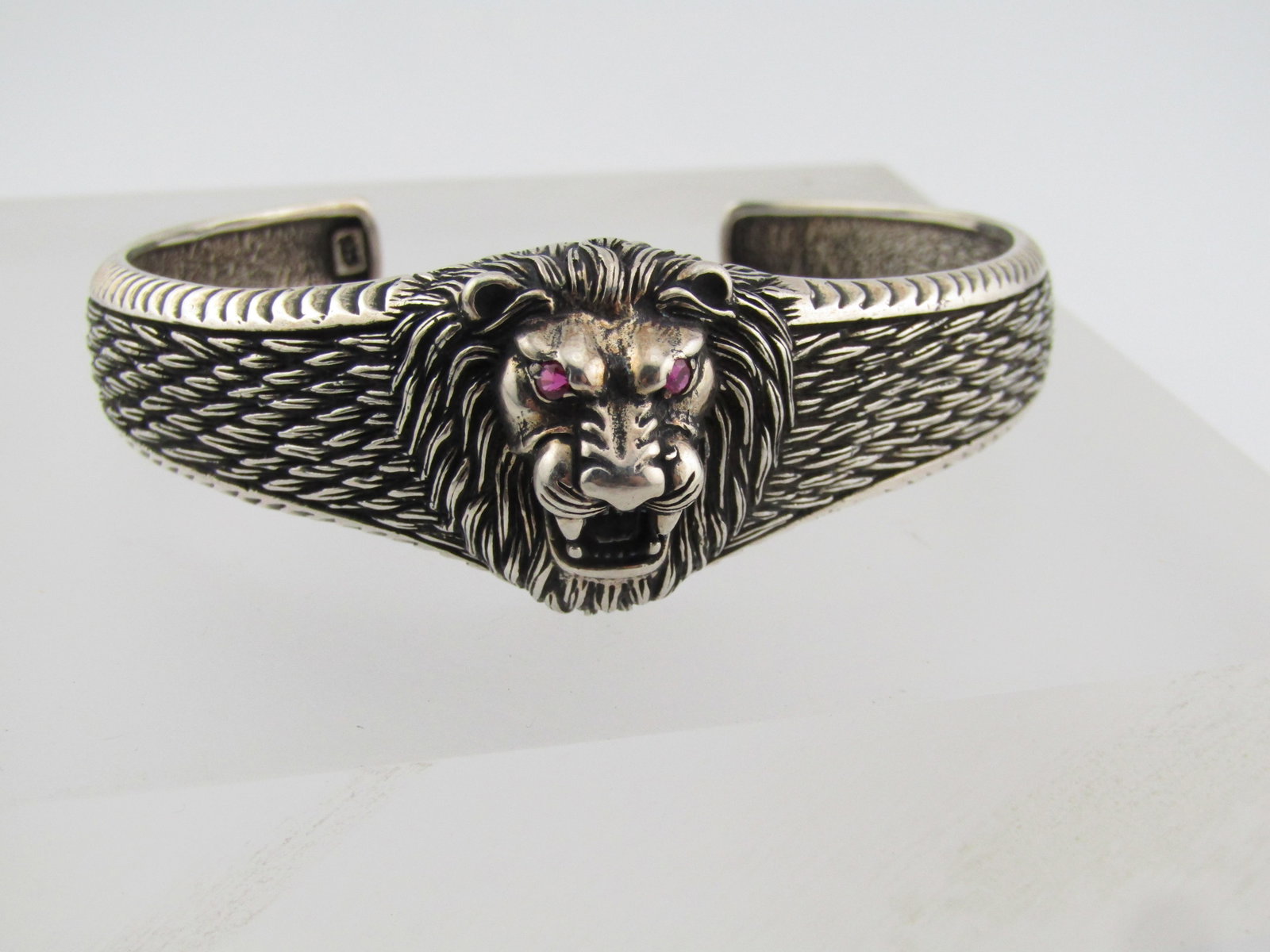 Sterling Lion Cuff Bracelet, Ruby Eyes, 7.25": Sterling Lion Cuff Bracelet, Ruby Eyes, 7.25". Age is appx. 1990's and after. Unisex. This is marked sterling and tests as sterling with an appx weight of 33.56 grams. It has a raised lion head at