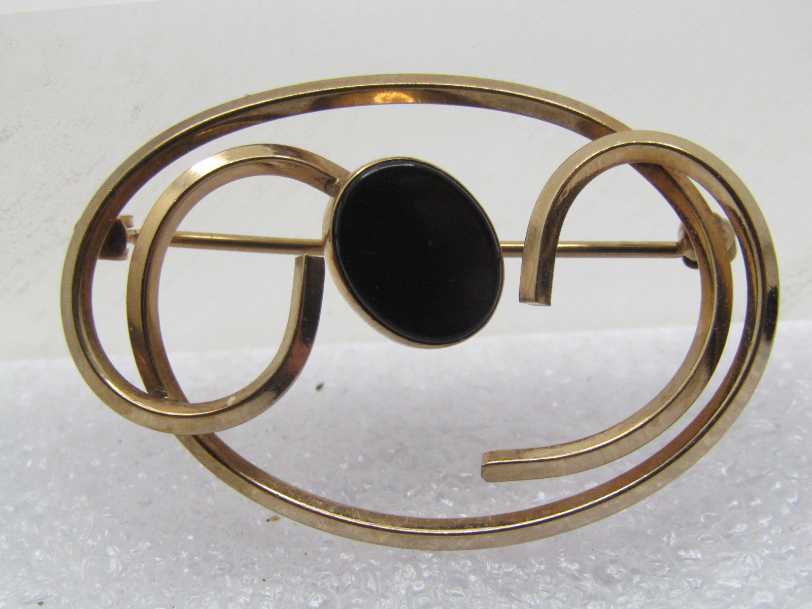 Vintage 12kt G.F. Onyx Scrolled Brooch, 1960's: Vintage 12kt G.F. Onyx Scrolled Brooch, 1960's. Yellow gold filled that test as 12kt-14kt gold fille. Weight of the brooch is appx. 3.15 gr. It is appx. 1.5" by 1". the scrolled gold filled metal is a