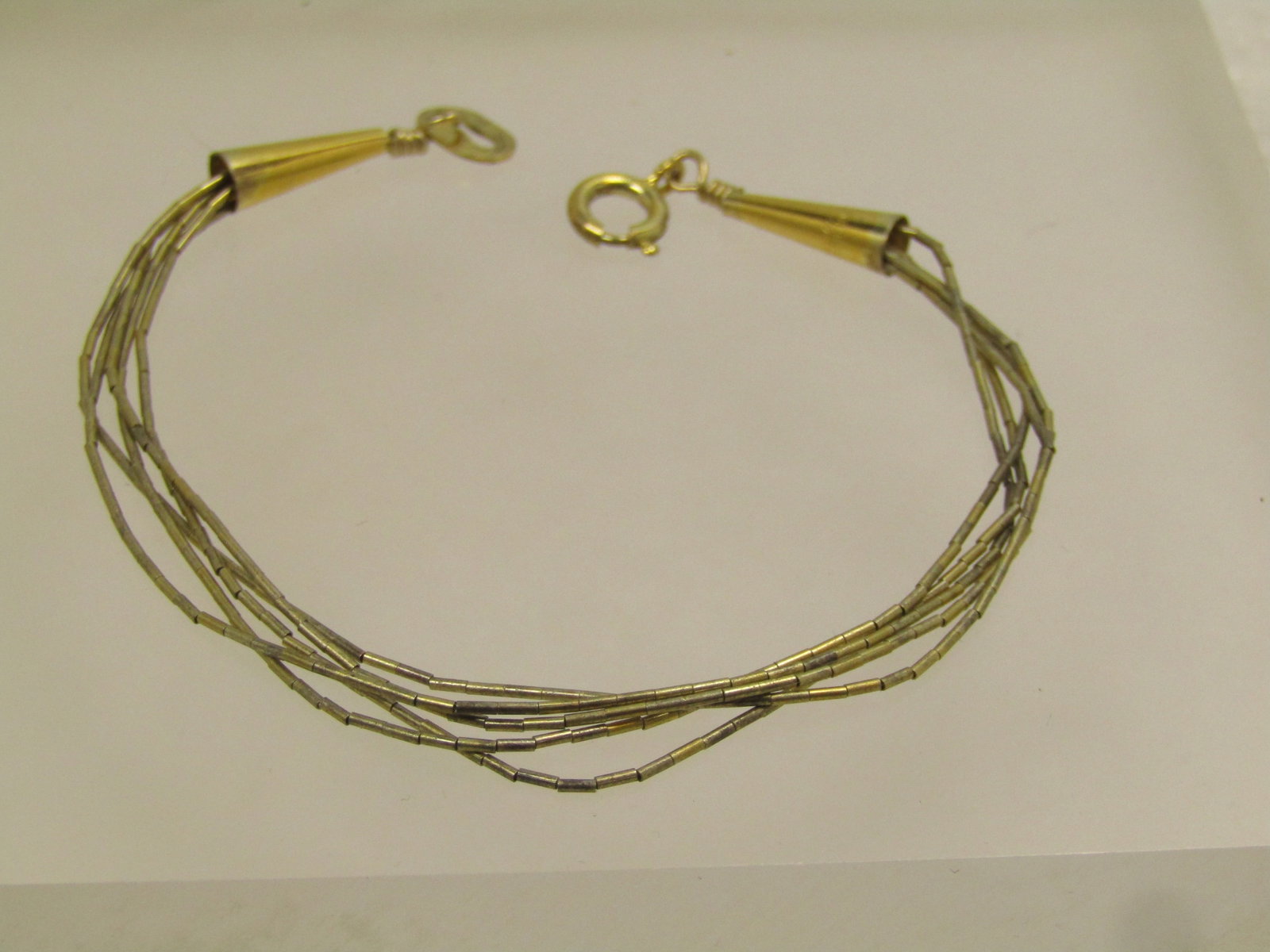 Vintage Sterling Vermeil Southwestern Bracelet, Liquid Silver Five Strand, 1980's: Vintage Sterling Vermeil Southwestern Bracelet, 7.25". Liquid Silver Five Strand, 1980's. Age is estimated at 1980's. This has a gold tone finish over the silver. This has conical end caps that are ma