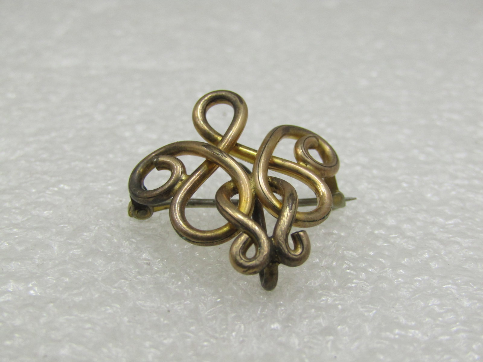 Victorian 10kt G.F. Ladies Brooch with Watch Hook: Victorian 10kt G.F. Ladies Brooch with Watch Hook. Looped curved design that is appx. 1" tall and wide". Not signed or marked, tests as 10kt G.F. Age is late 1800's. Light wear but very good condition