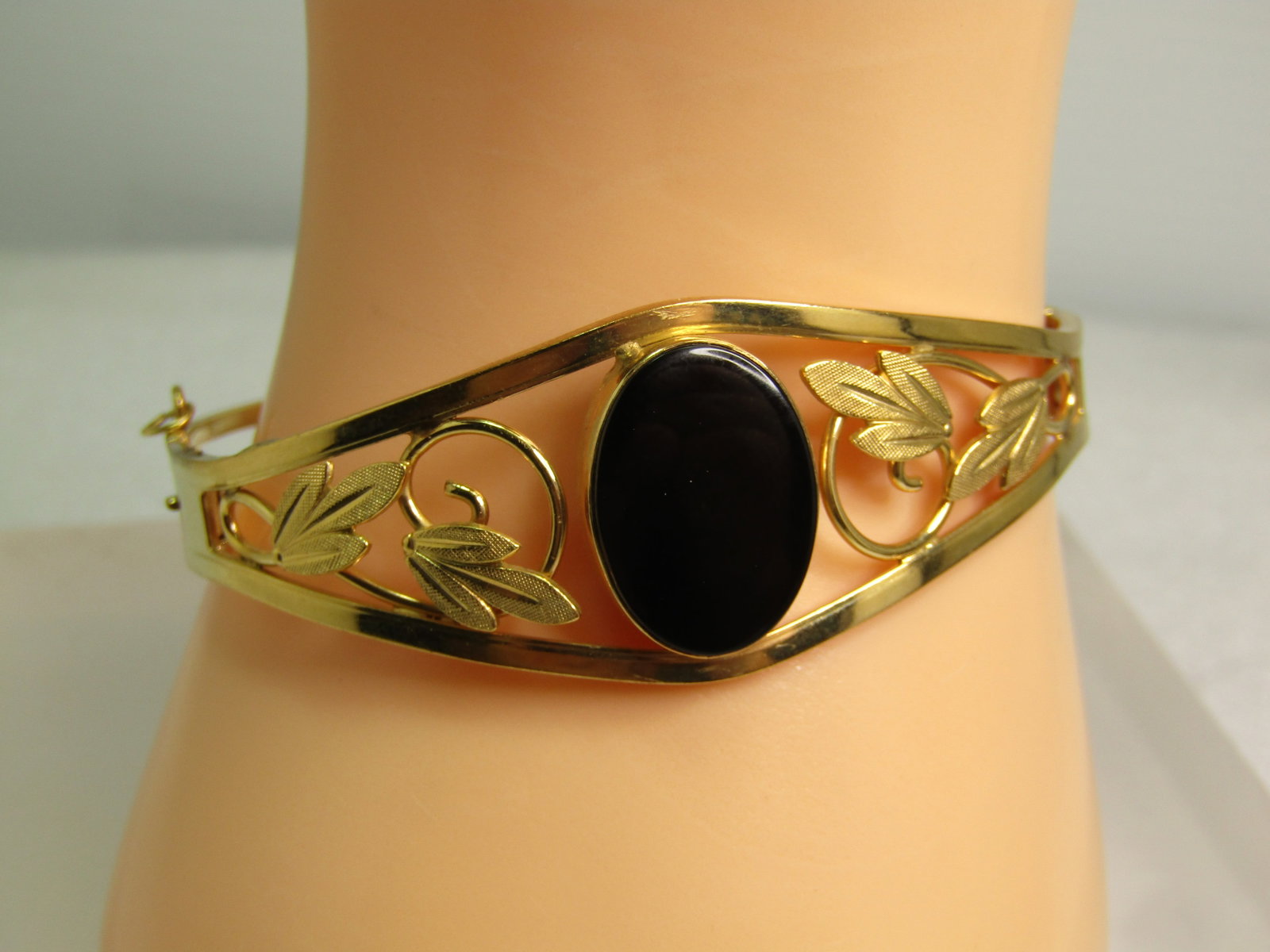 Vintage 12kt G.F. Onyx Hinged Clamper Bracelet, 6.5", 1970's, Signed Van Dell: Vintage 12kt G.F. Onyx Hinged Clamper Bracelet, 6.5", 1970's, Signed Van Dell. This has an appx. 3/4" black onyx bezel-set raised cabochon in the center with coiled and leaf accents with open work